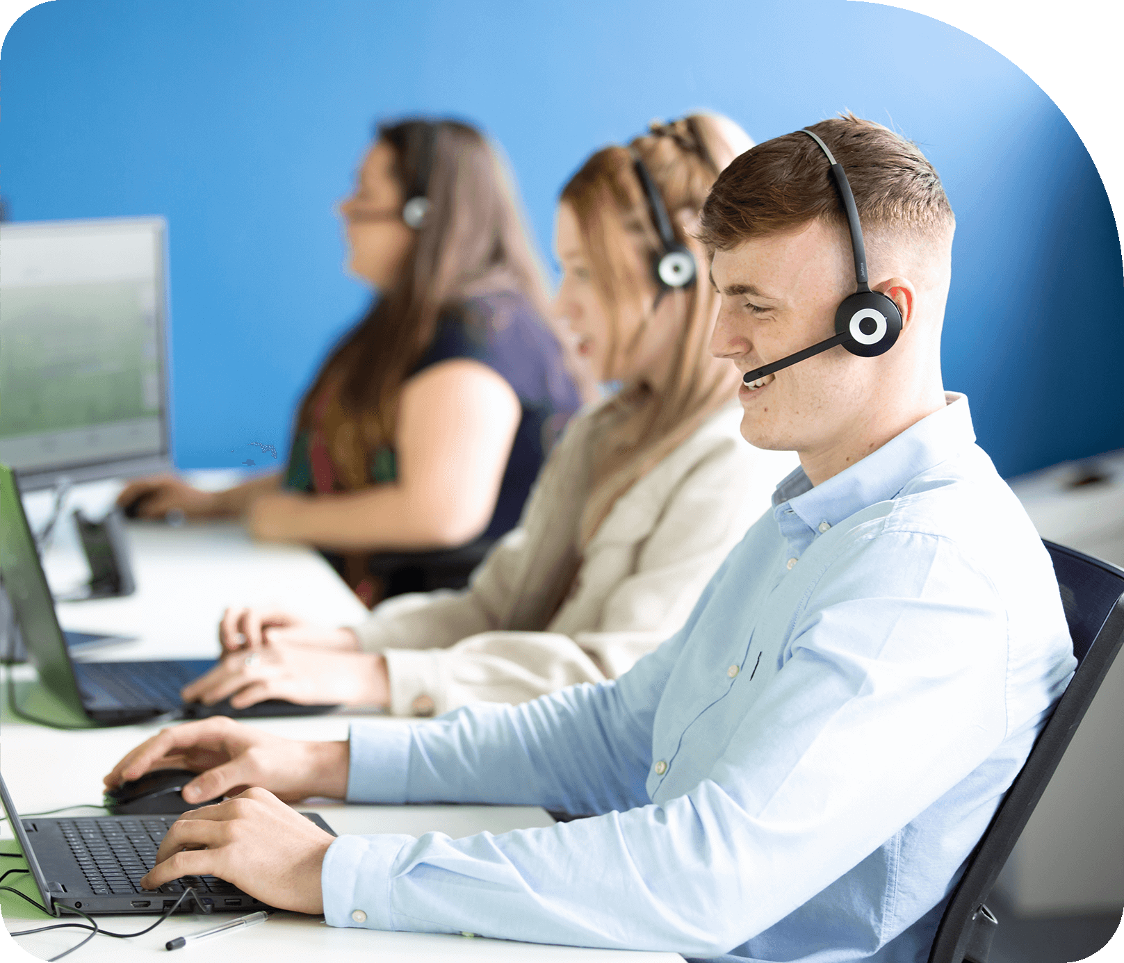 A photo of three members of craggs energy staff sat at their desks wearing a headset. Careers